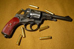 Револьвер Наган на фоне пуль